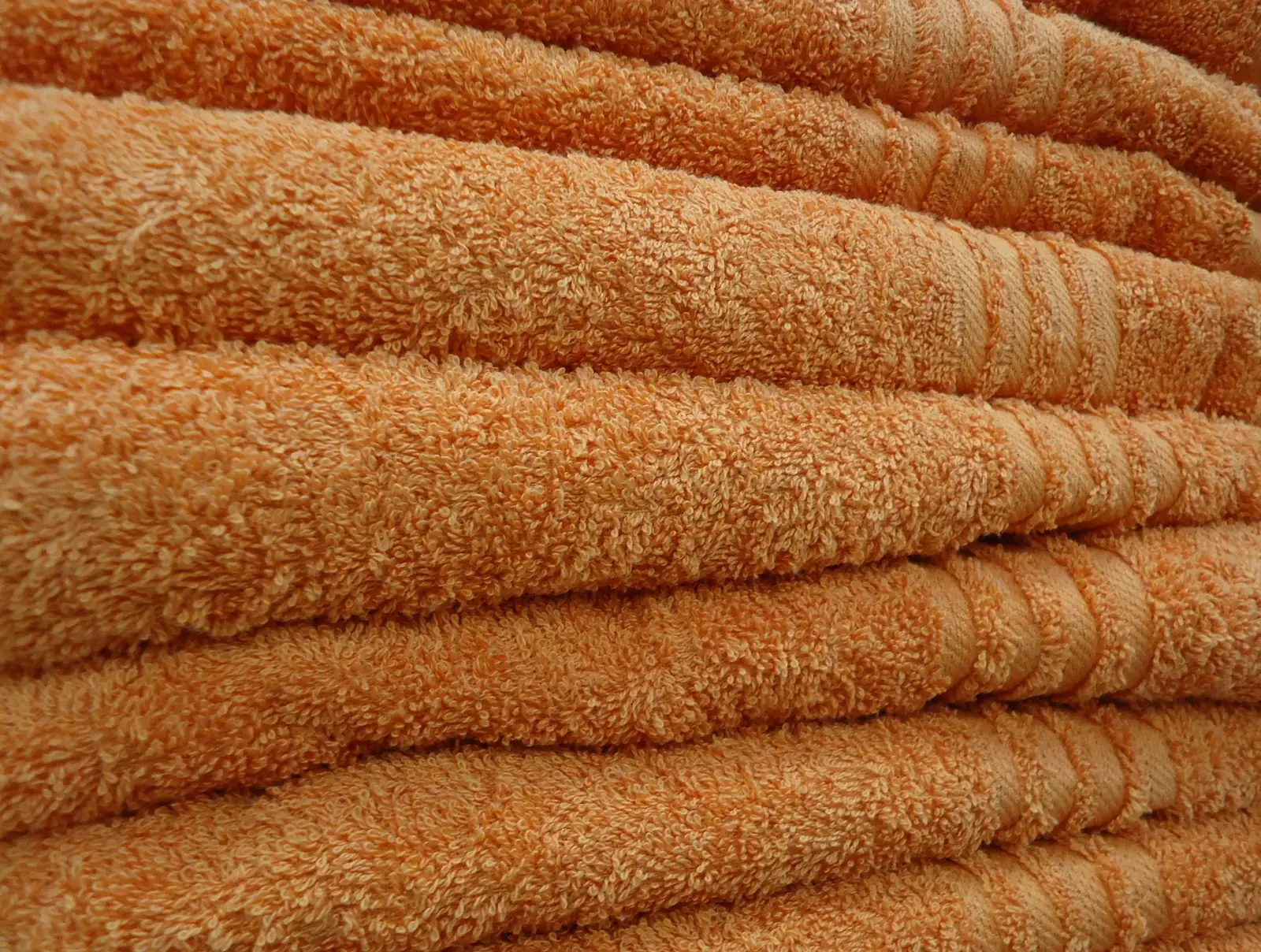 Folded orange towels stacked in a pile